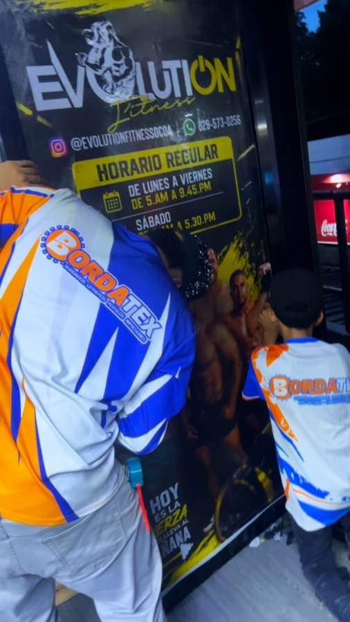 Equipo Bordatex instalando un rótulo en un gimnasio